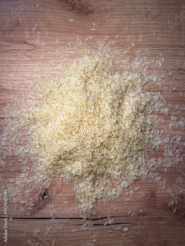Top view of a heap of raw parboiled rice isolated on wooden background. Healthy food. Close up, high resolution product
