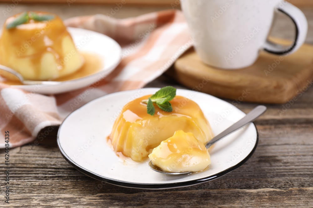 Delicious pudding with caramel sauce and mint served on wooden table Delicious pudding with caramel sauce and mint served on wooden table