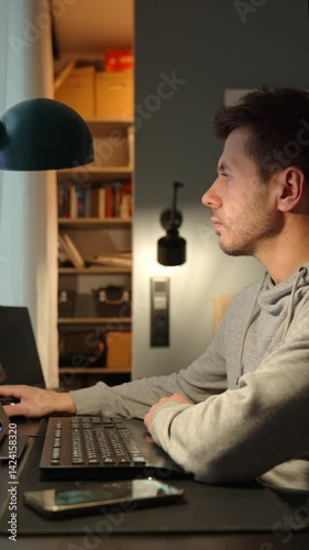 Wallpaper Mural Man sitting at desk in living room and using computer for remote work. Male freelancer working at home office Torontodigital.ca