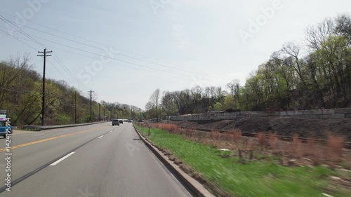 Car driving on road point-of-view POV in greater Pittsburgh, PA area in north hills of roads, infrastructure, hills, lanes, buildings, homes, and businesses close to West Virginia landscape scenary 