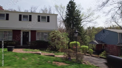 Moving past Pittsburgh, PA greater area suburbs and neighborhood homes in western Pennsylvania in warm, sunny spring weather in April of residential areas in North Hills suburban roads and houses