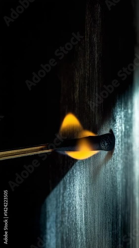 A burning matchstick igniting and fading slowly with smoky trail