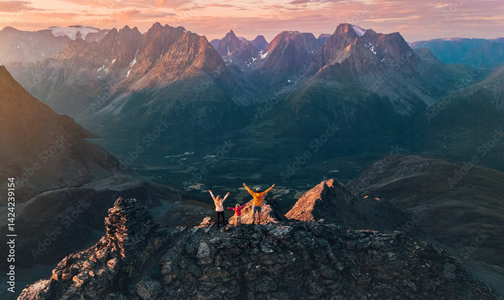 Naklejka premium Family climbing mountains in Norway - aerial view travel lifestyle mother, father, and child on the top adventure trip people on active summer vacations extreme tour outdoor in Lyngen Alps landscape