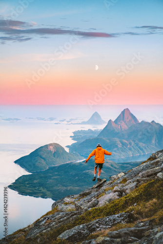 Travel in Norway - man hiking solo in mountains active adventure summer vacations, tourist exploring wild Scandinavian nature healthy lifestyle freedom concept islands and sea landscape moon and dawn