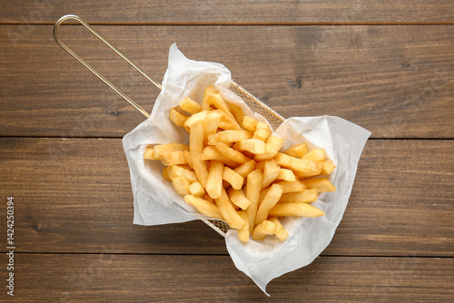 Tasty french fries on wooden table, top view