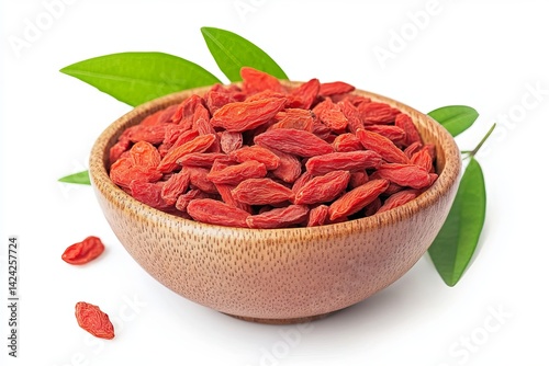 Dried goji berries in a wooden bowl, isolated on a white background with green leaves, front view.