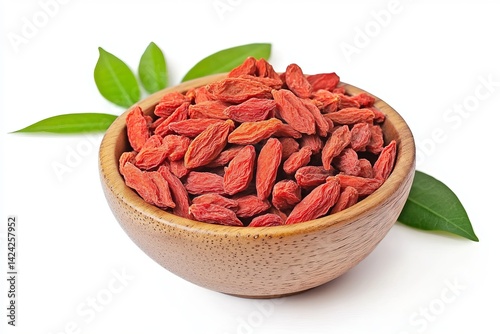 Dried goji berries in a wooden bowl, isolated on a white background with green leaves, front view.