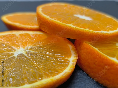 sliced ​​round tangerine slices lie on a granite board.