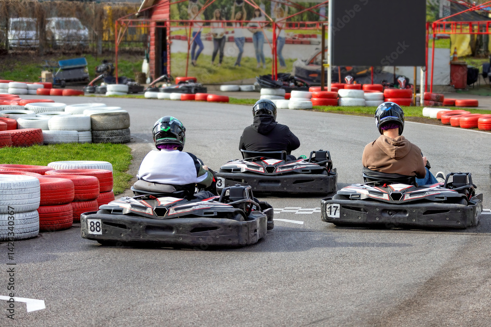 Racing excitement at a karting circuit on a bright day with friends enjoying the thrill together