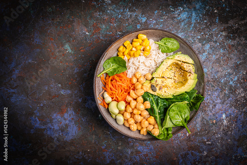 Poke bowl with spinach, avocado, corn, green salad, chickpeas, carrot and rice, dark background, top view. Concept of healthy eating, dieting