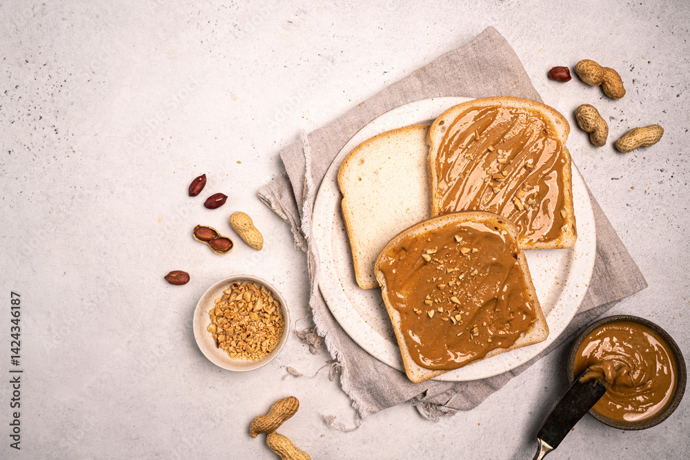 Peanut butter sandwiches on plate. Sliced bread with nuts spread. Top view of healthy protein breakfast or snack. Vegetarian lunch. Copy space.