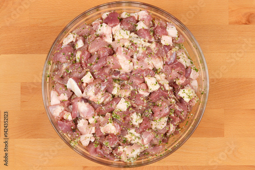 Obraz na płótnie Diced and seasoned pork meat, ready for sausage making, is presented in a round glass bowl on a wooden background w salonie
