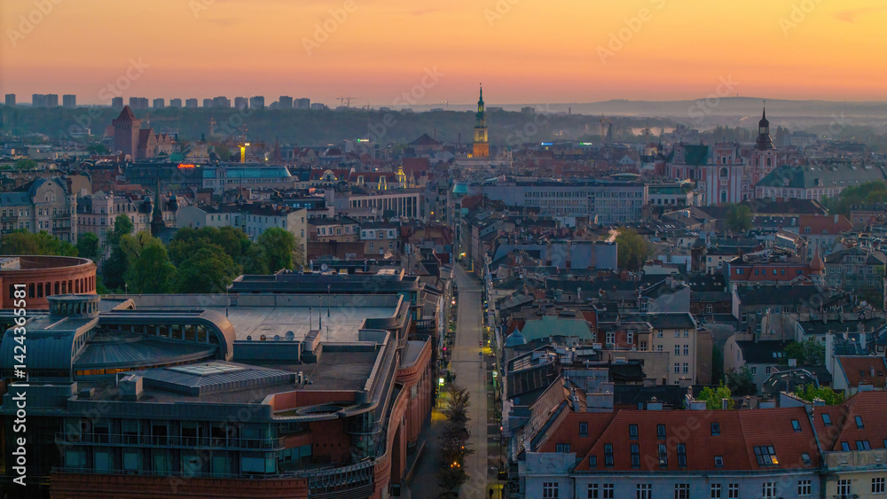Obraz premium Cityscape of Poznań, Greater Poland, Poland — aerial top view of Polwiejska Street with the city hall visible in the distance at dusk.