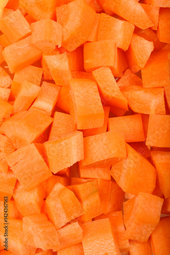 Obraz na płótnie A close-up, top-down shot shows a dense pile of raw, vibrant orange diced carrots w salonie