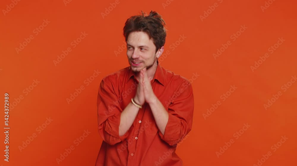 Sneaky cunning Caucasian young man with tricky face gesticulating and scheming evil plan, thinking over devious villain idea, cheats, jokes, pranks. Handsome guy isolated on orange studio background Sneaky cunning Caucasian young man with tricky face gesticulating and scheming evil plan, thinking over devious villain idea, cheats, jokes, pranks. Handsome guy isolated on orange studio background