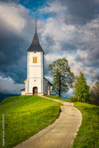 Rural pathway and Saint Primoz church on the hill, Slovenia