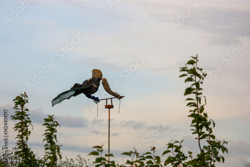 Scarecrow among the branches in the evening twilight