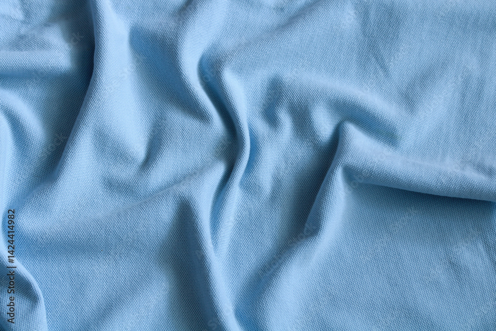 Light blue fabric texture background showing soft ripples and folds Light blue fabric texture background showing soft ripples and folds