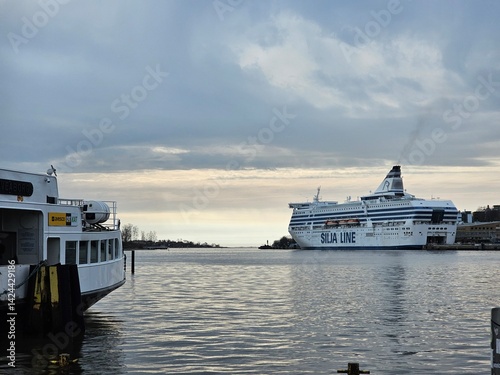 Finland, Helsinki - March 11, 2025: Discovering the city of Helsinki in winter days. Citysighting the old port of the city. Cloudy sky reflected over the northern sea.