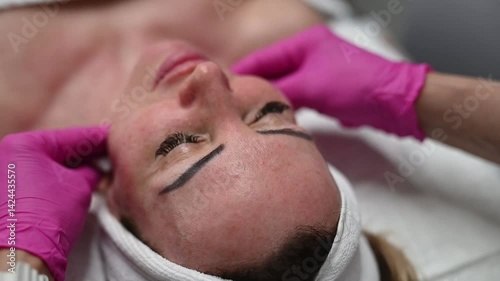 Facial massage close-up horizontal video — A cosmetologist gently performs facial massage, focusing on relaxation and skin stimulation. Vertical format, ideal for beauty, wellness, and skincare stock.