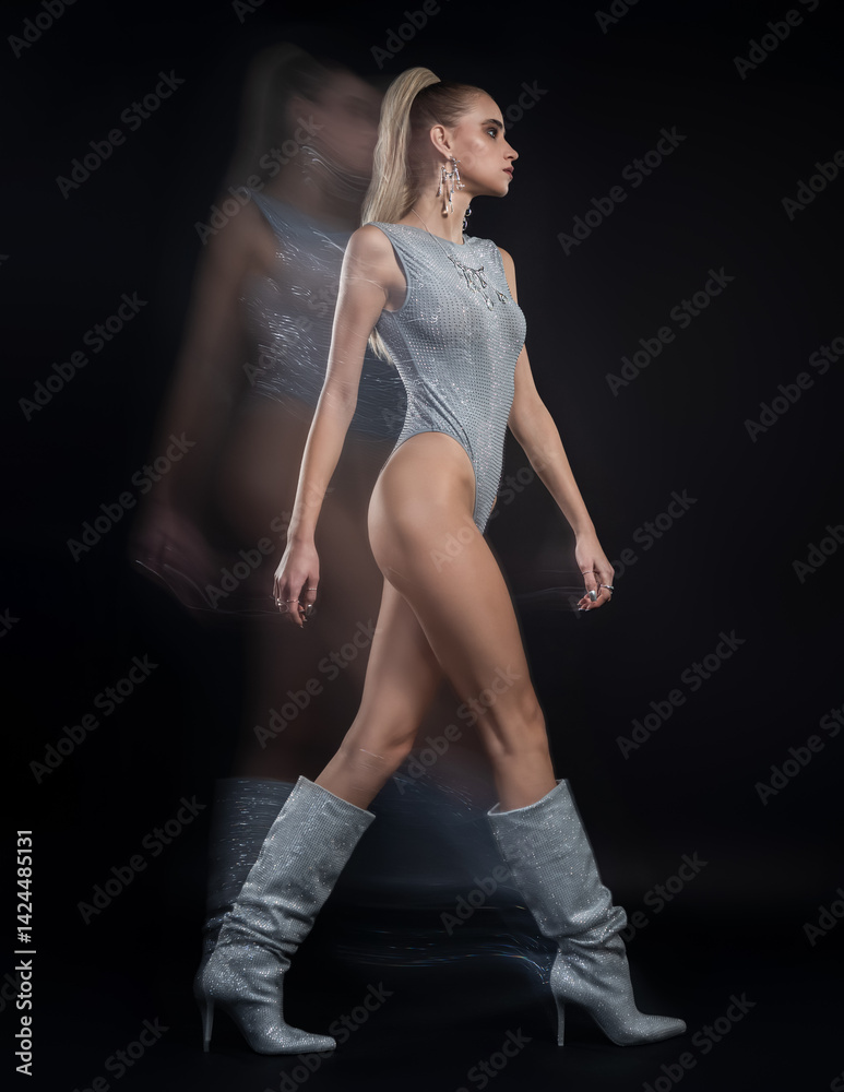 Fashion portrait of beautiful model in silver top and boots and silver jewelry. Motion blur added intentionally