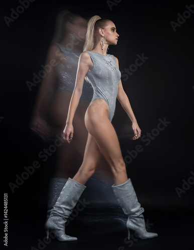 Fashion portrait of beautiful model in silver top and boots and silver jewelry. Motion blur added intentionally