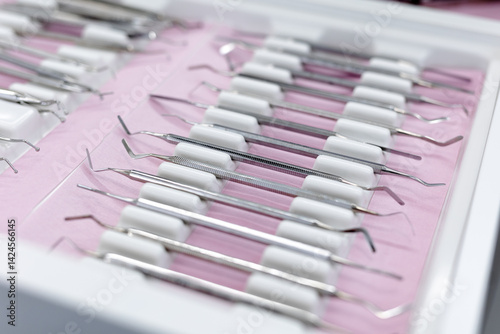 Close-up of sterilised dentist's instruments for working on teeth arranged on medical cabinet. Dental health concept