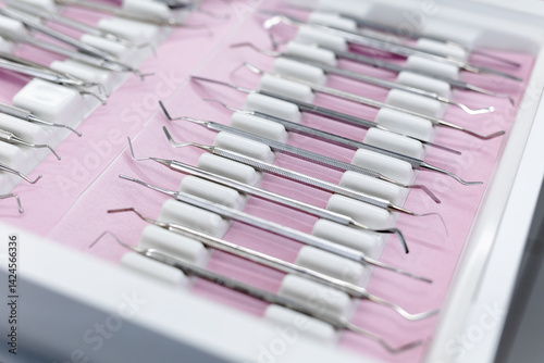 Close-up of sterilised dentist's instruments for working on teeth arranged on medical cabinet. Dental health concept
