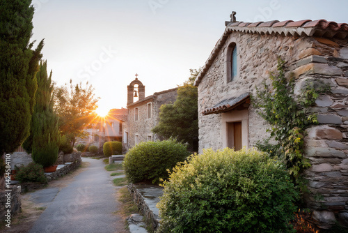 simple village church with stone walls and bell tower at sunrise.