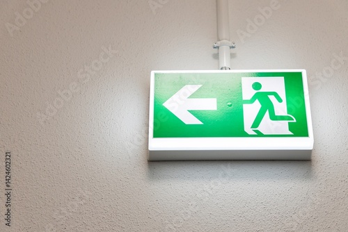 Fire Emergency exit sign on the wall background inside building. Safety concept
