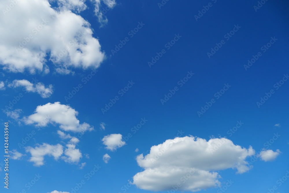 White fluffy clouds in the sky. Blue sky and cloud cover on a sunny summer day. Empty background, copy space White fluffy clouds in the sky. Blue sky and cloud cover on a sunny summer day. Empty background, copy space