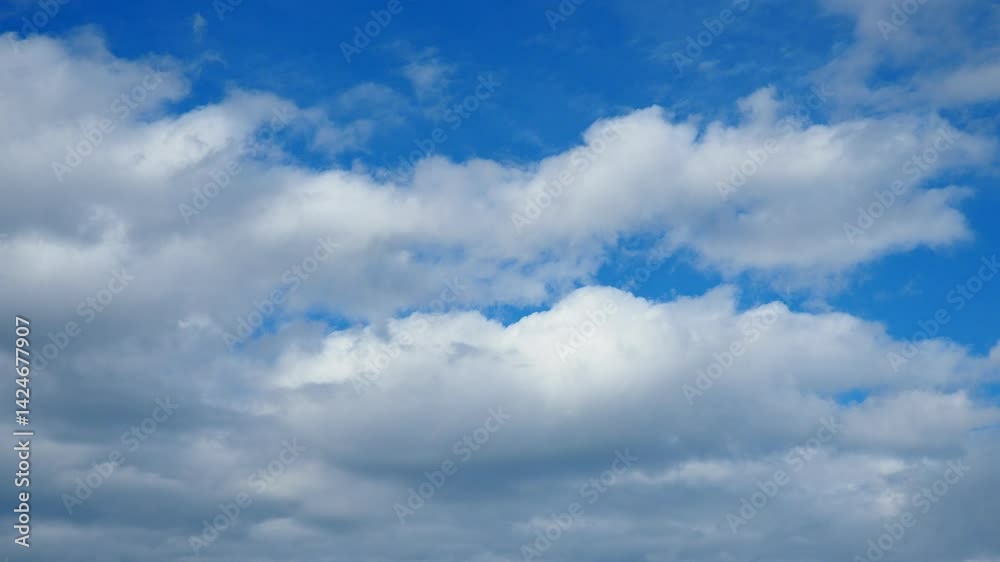 Soft, white clouds float lazily in a brilliant blue expanse, creating a serene atmosphere. The sun shines brightly, casting shadows that shift subtly as the clouds drift. Real time, slow motion sky Soft, white clouds float lazily in a brilliant blue expanse, creating a serene atmosphere. The sun shines brightly, casting shadows that shift subtly as the clouds drift. Real time, slow motion sky