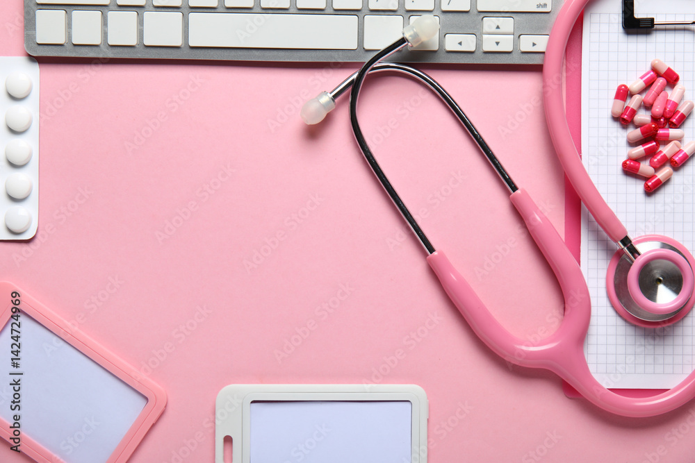 Frame made of stethoscope, pc keyboard, badges and pills on pink background