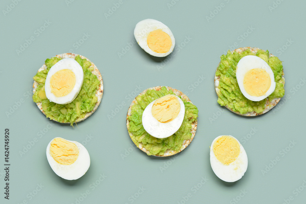 Rice crackers with boiled eggs and avocado on grey background
