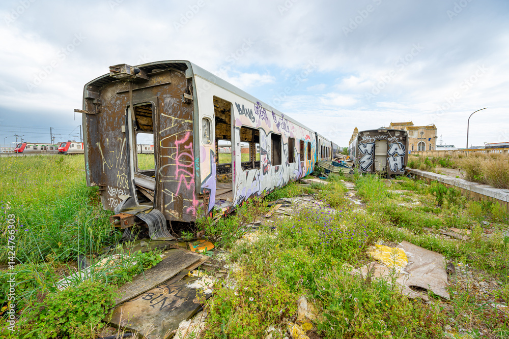 Fototapeta premium Destroyed, dilapidated and abandoned passenger train carriages next to the disused railway station in the city of Barreiro-Portugal.