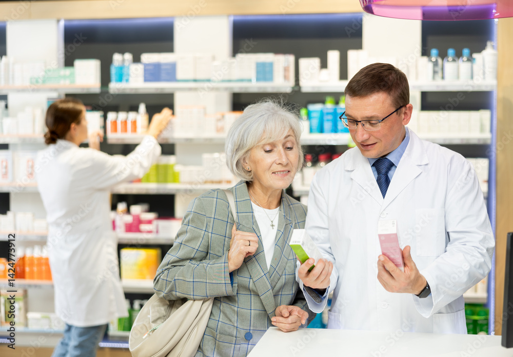 Elderly woman client consults with a pharmacist which medicinal ointment to buy