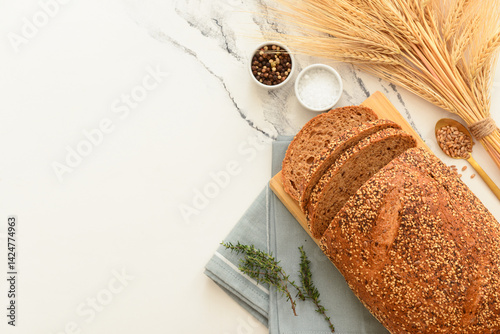 Obraz na płótnie Wooden board with sliced loaf of bread, wheat spikelets, grains and thyme on white grunge background w salonie