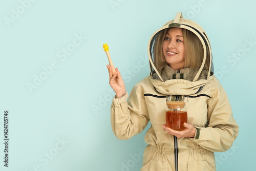 Female beekeeper with jar o...