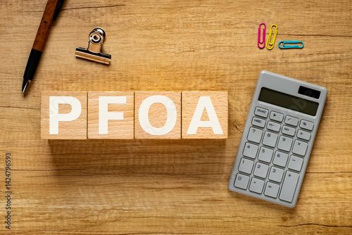 There is wood cube with the word PFOA. It is an abbreviation for Per Fluoro Octanoic Acid as eye-catching image. photo