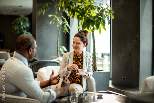 Business colleagues having a casual meeting over coffee in modern hotel lounge photo
