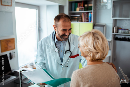 Smiling senior doctor talking to female patient during medical consultation in clinic