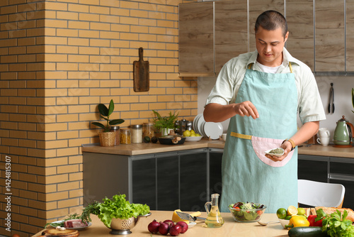 Young man spicing vegetable...