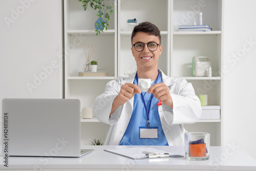 Young doctor showing condom...