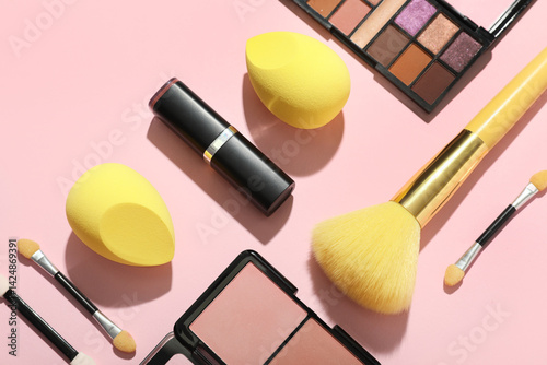 Obraz na płótnie Makeup sponges with yellow brush and different decorative cosmetics on pink background, closeup w salonie