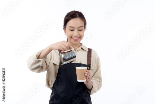 Portrait young asian woman barista work happy holding milk jug pour in coffee cup isolated white background, joyful barista wearing apron holding pitcher and coffee cup, small business or startup.