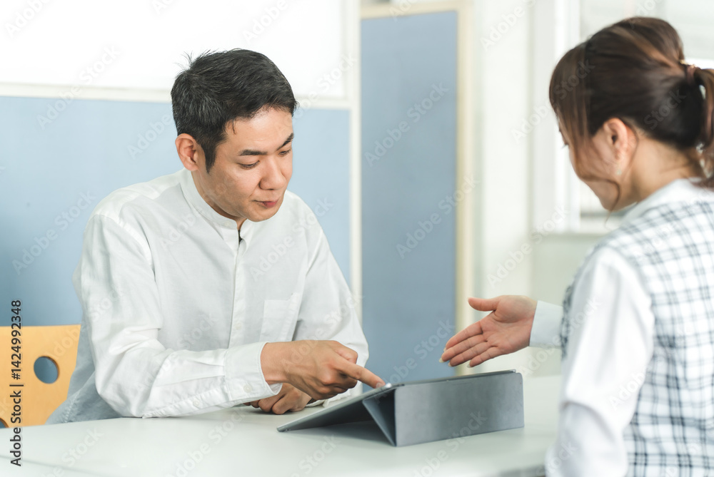 受付カウンターで話を聞く男性客と説明する女性スタッフ
受付カウンターで話を聞く男性客と説明する女性スタッフ
