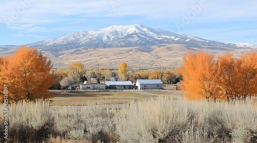Autumnal landscape Snow-capped mountain behind rural houses and golden trees.  Perfect for travel brochures or real estate