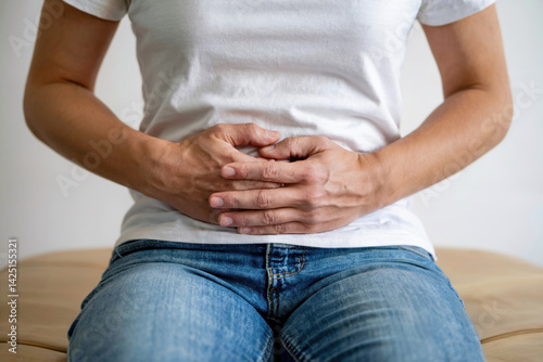 Person holding stomach with discomfort