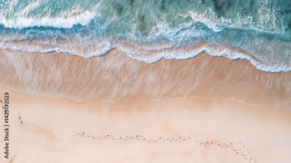The image captures an aerial view of a beach with clear turquoise waves gently crashing onto the shore