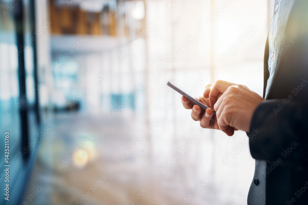 The image shows a close-up of a person's hands holding a smartphone, likely in a professional setting, as indicated by the blurred background with office-like elements